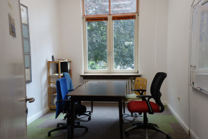 Der Besprechungsraum, Blick auf Tisch mit Stühlen und aus dem Fenster