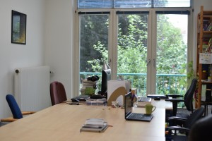 Einer der Arbeitsräume, Blick auf Tische und aus dem Fenster